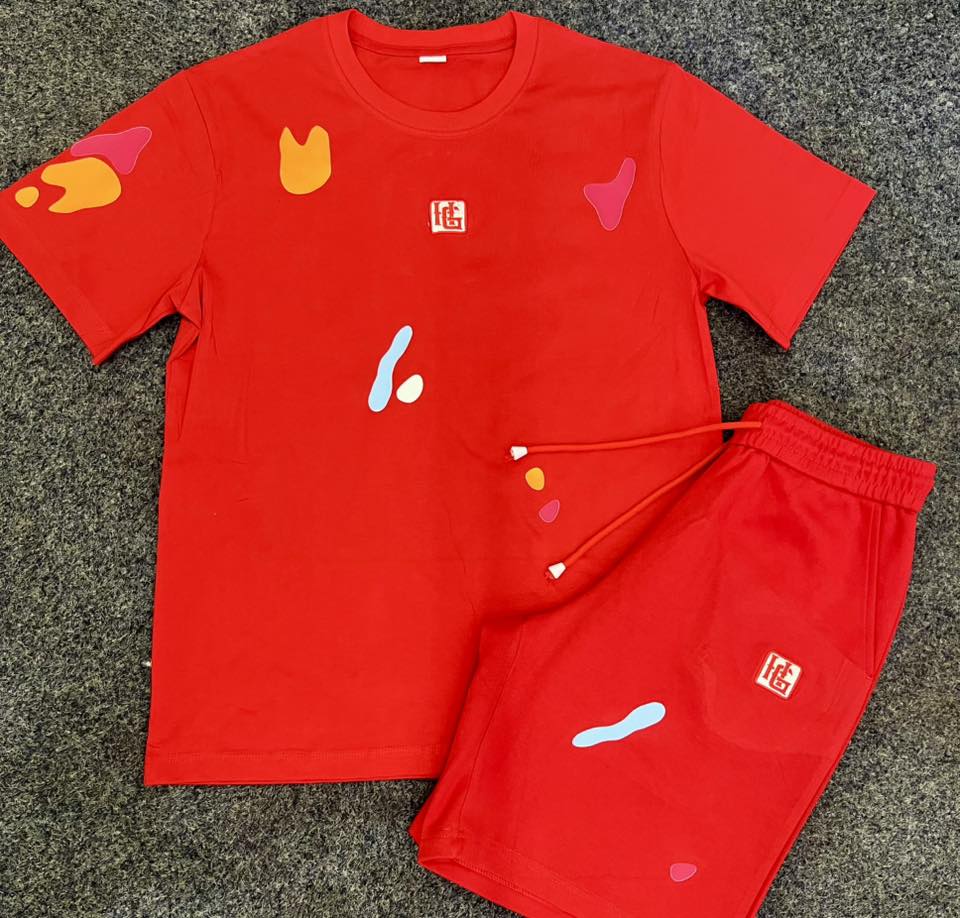 Red t-shirt and shorts set with colorful designs on a gray surface
