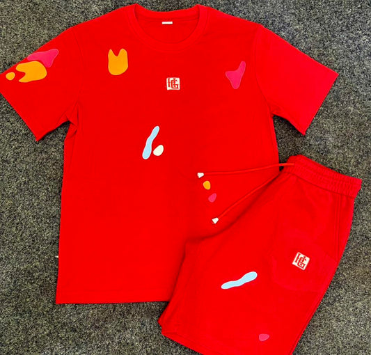 Red t-shirt and shorts set with colorful designs on a gray surface